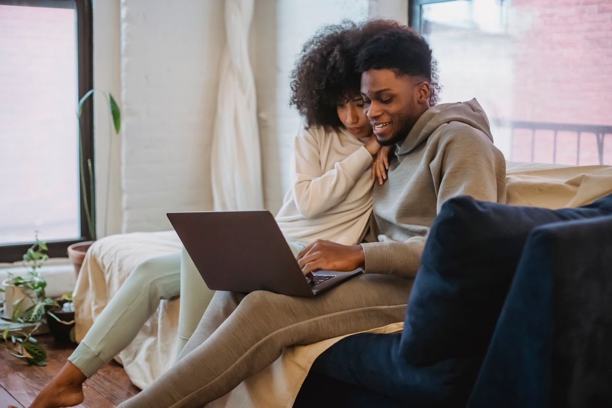 Une femme pose la tête sur l’épaule de son compagnon, sur le canapé