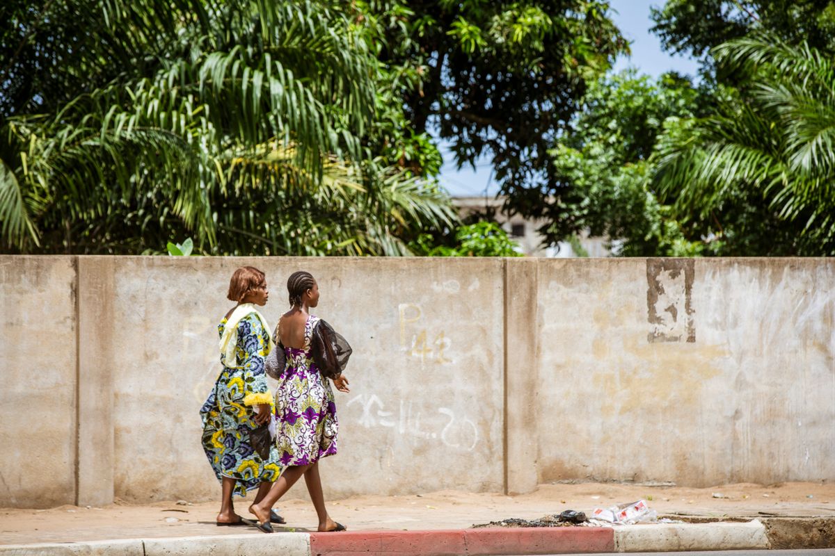 Deux femmes en tenue africaine marchent dans une rue de Lomé